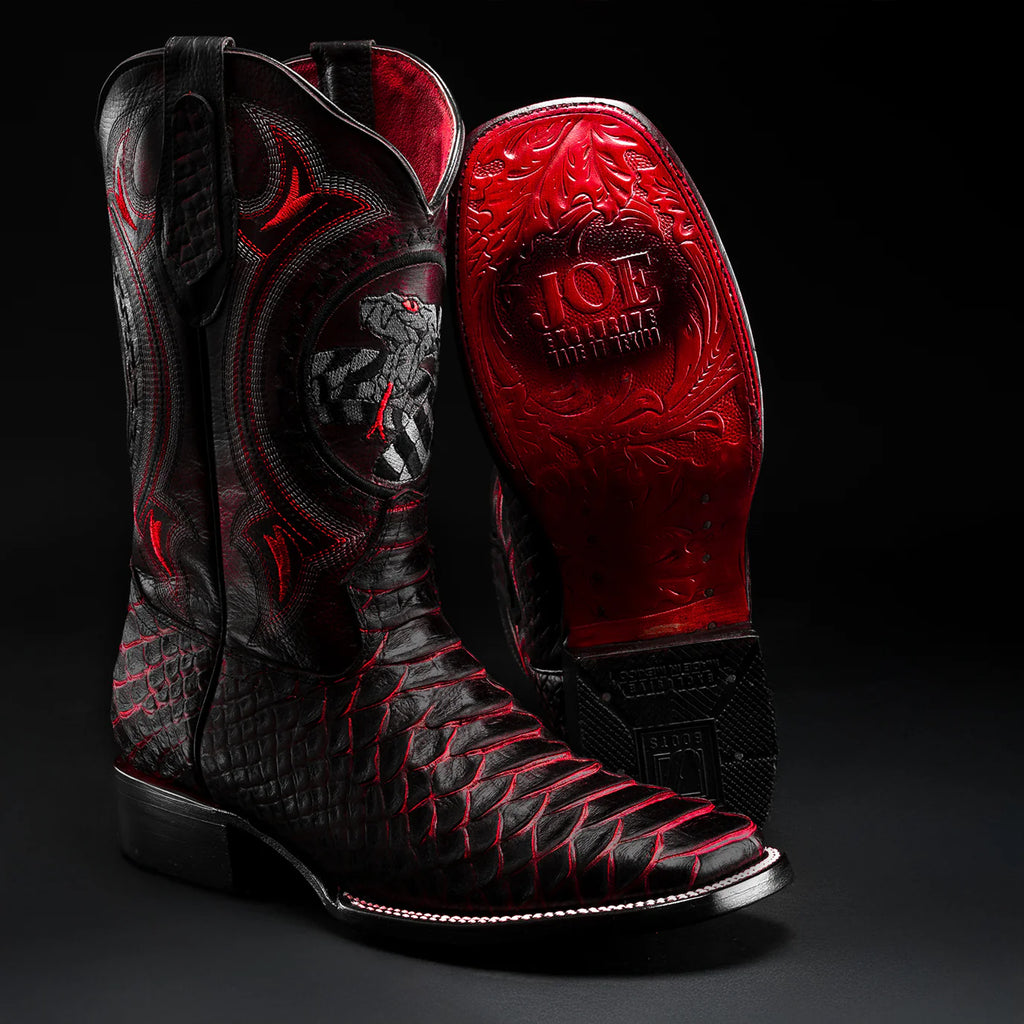 Black and red cowboy boots with intricate designs on a black background
