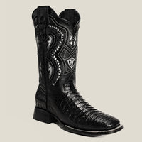 Black cowboy boot with intricate white embroidery on a light gray background