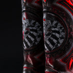 Close-up of a black and red boot with intricate patterns on a dark background