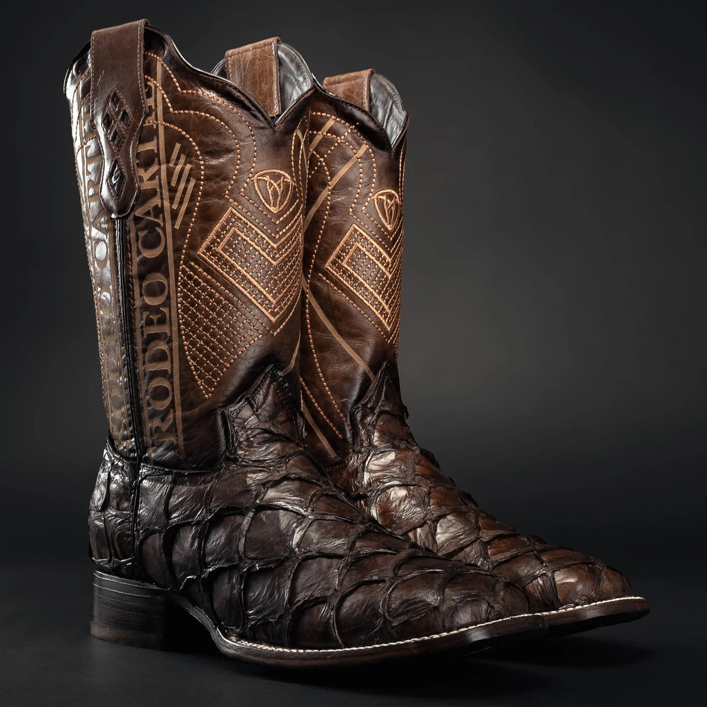 Brown leather cowboy boot with intricate patterns on a black background