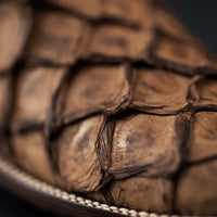 Close-up of stacked brown leather-bound books with a blurred background