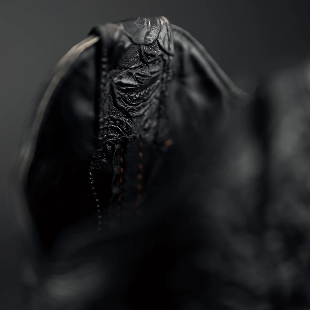 Close-up of a textured black cow boy boot with a blurred background