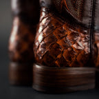 Close-up of brown leather boots with detailed texture on a dark background