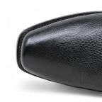 Close-up of a black leather shoe sole on a white background